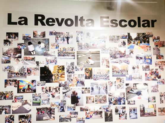 Mural de fotografías de acciones ciudadanas realizadas por niñes contra el tráfico y la contaminación del aire.
Sobre el mural en letras grandes pone La Revolta Escolar.