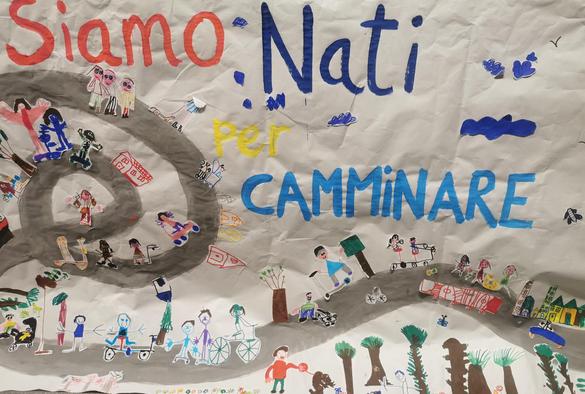 Mural pintado por alumnes con un diseño de ciudad sostenible. En letras grandes de colores se lee en italiano " hemos nacido para caminar"