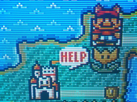 A close up picture of World 4 on the Super Mario All-Stars version of Super Mario Bros 3 displayed on a Sony KV-27FS210. Raccoon suit Mario is standing up and to the right diagonally from the end castle, with a speech bubble displaying the text "HELP" adjacent to it