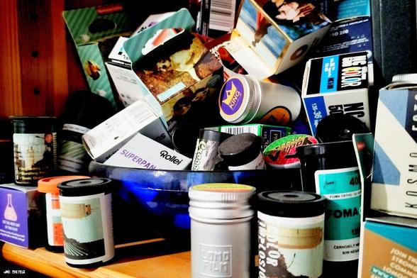 Farbfoto - Nahaufnahme einer Sammlung von Filmschachtel und Büchsen verschiedener Marken und Formate - 35 Millimeter und Mittelformat, darunter Ilford, Foma, Solaris, Cinestill und Lomography.