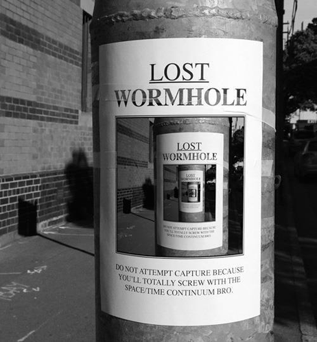 Poster pasted to a telephone pole showing a picture of the poster showing a picture of the poster again, and again, ad infinitum, with the text Lost Wormhole: Do not attempt capture because you'll totally screw with the space/time continuum bro.