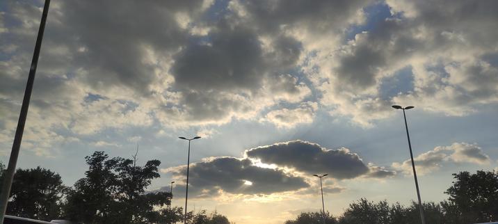 Photo de nuages où perce une lueur du soleil couchant