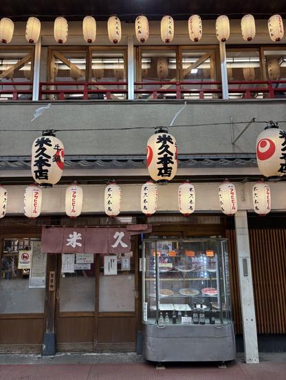 A building with Japanese lanterns shining in the early evening