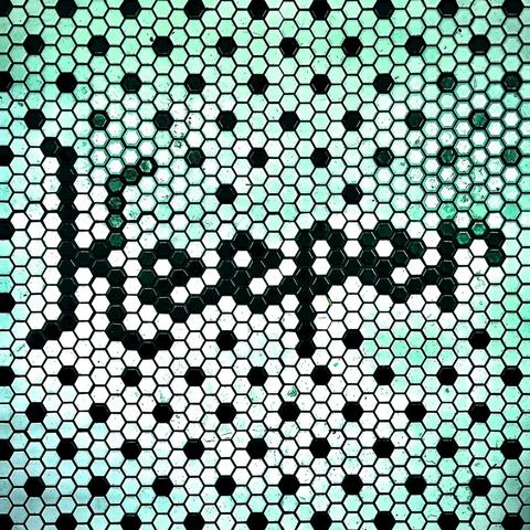 A hexagonal, white mini-tile floor with turquoise accent lighting reflecting off it displays the word, "Keeper," centered in black tiles.
