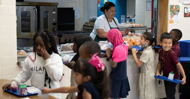 Children getting food in a school cafeteria: