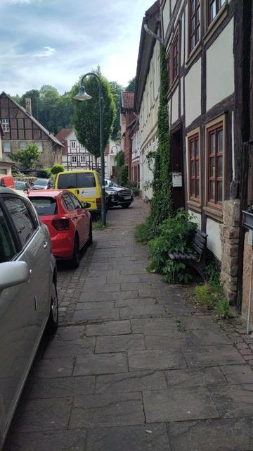 Auto steht mit Motorhaube auf dem Bürgersteig