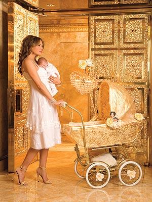 Family photo showing Melania in an ornate golden room with golden floor pushing a golden baby stroller outside a golden hallway.