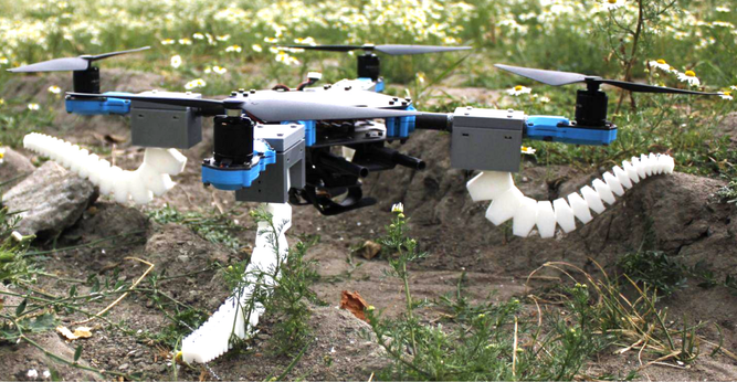 A grey and blue drone with four rotors. It has four flexible white plastic legs that resemble the legs of an octopus.