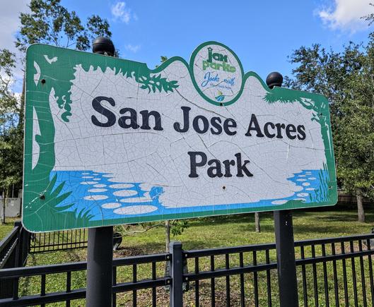 City signage for a small, fenced, neighborhood park reads: San Jose Acres Park.