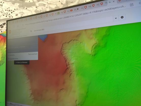 Foto eines Bildschirms, auf dem die Seentiefenkarte von map.geo.admin.ch dargestellt wird. Bei genauerer Betrachtung kann eine kleine Erhebung am dargestellten Seeboden erkannt werden - an dieser Stelle ist mal ein Schiff gesunken und liegt weiterhin am Serbo en.