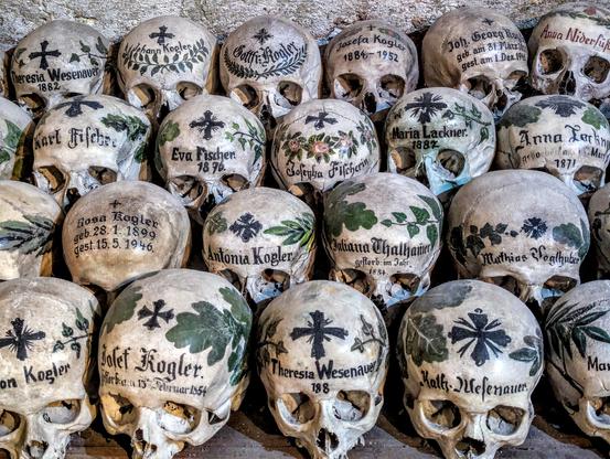 They did not rest in peace forever, because there was no more burial space. Painted skulls in the small ossuary at Pfarrkirche Mariä Himmelfahrt (Maria am Berg), in Hallstatt, Oberösterreich, Austria. May 2025.
