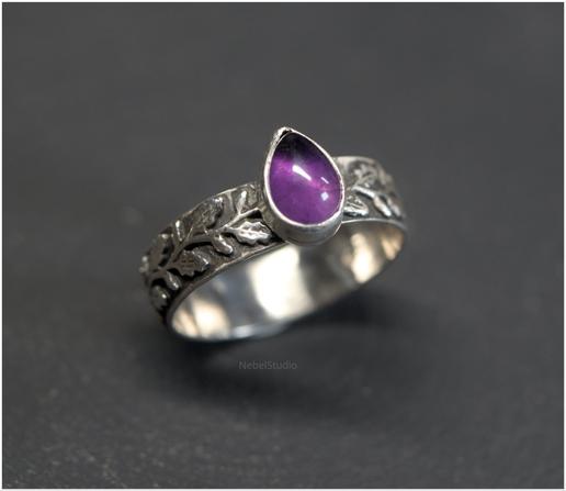 anillo de plata, es una banda decorada con hojas de roble y bellotas muy peques, y tiene engarzada una amatista en forma de lágrima.