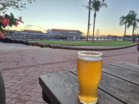 Photo of my beer on a table with sunset tinged Hillary's Boat Harbour in the background.