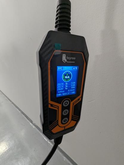 A detailed photo of the charger and its screen. The brand says "Feyree", the screen shows active charging with ~230V and 15A on two phases.