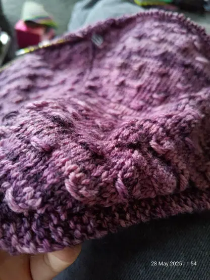 Close up of the texture of the smocking, with the rest of the shawl slightly out of focus in the background of the photo