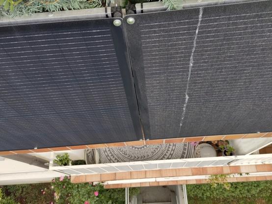 Zwei Solarpanele am Balkongeländer. Eines ist ganz grau und mit einer dicken Schicht aus Pollen und Staub bedeckt. Das andere ist bereits sauber.