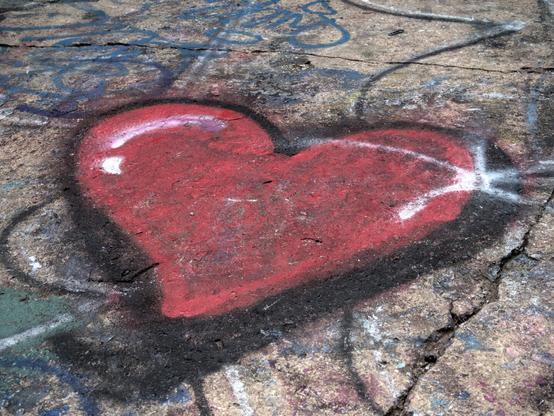 a heart with a sparkle spray-painted on the sidewalk