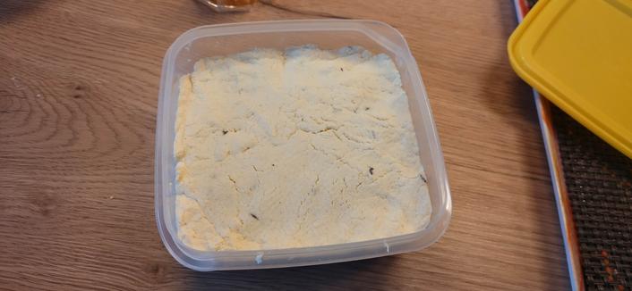 The cheese has been pressed down into the square container. Some indentations from my fingers are visible and only a little bit of the cheese cloth pattern.