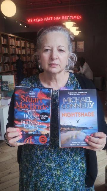 Bookseller Marie with the Stuart MacBride's The House of Burning Bones, and Michael Connelly's Nightshade, in the Edinburgh Bookshop