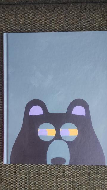 Removing the dustjacket to show a cartoon bear on the hardback front cover