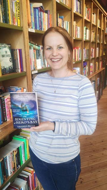 Author Amanda Block with an advance copy of her next novel, The Haunting of Hero's Bay, in the Edinburgh Bookshop