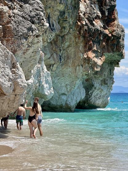 People wade around cliffs to reach smaller secluded swimming spots