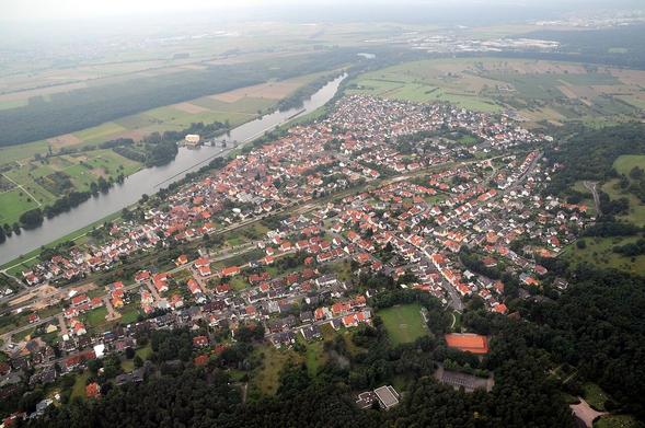 Obernau am Main, Bayern, Deutschland, Luftaufnahme
Links oben ist der Main mit Staustufe und Wasserkraftwerk zu erkennen. Es wurde 1930 in Betrieb genommen.
(Bild: Wikimedia Commons, 2008, CC-BY-SA 3.0, Fritz Geller-Grimm supported by Rüdiger Wandke)