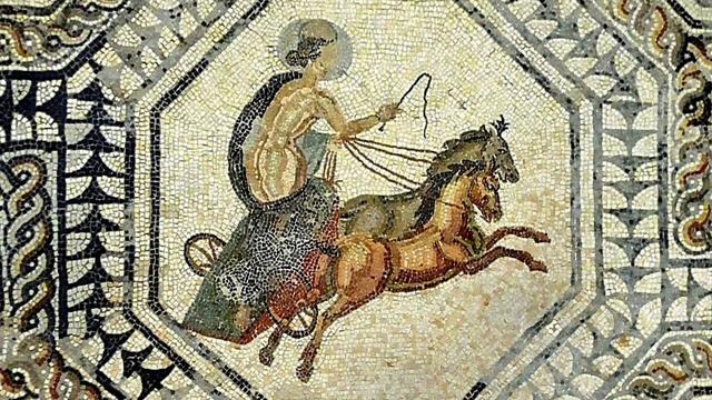 The picture shows a detail of a mosaic depicting female figure in a chariot pulled by two horses. The goddess holds the reins in one hand and a whip in the other.