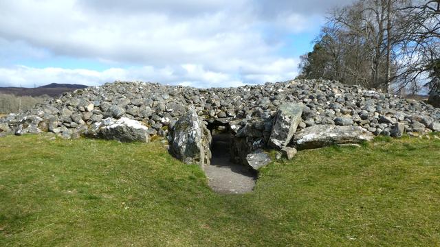 Tunnel entrance leading through a huge stone cairn into a circular, central, chamber