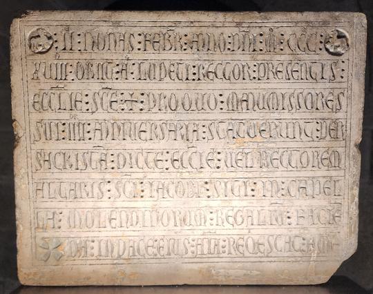 Almost square stone with eight inscribed lines of heavily-abbreviated Latin.