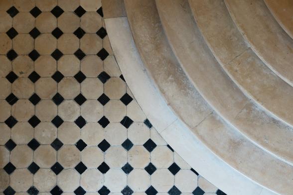 Floor tiles with a black and white pattern, a stair at the right side