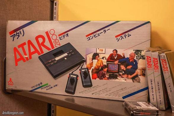A boxed Atari 2800, the Japanese Atari 2600, and 3 boxed games. Photo by @Amimoregore@mas.to