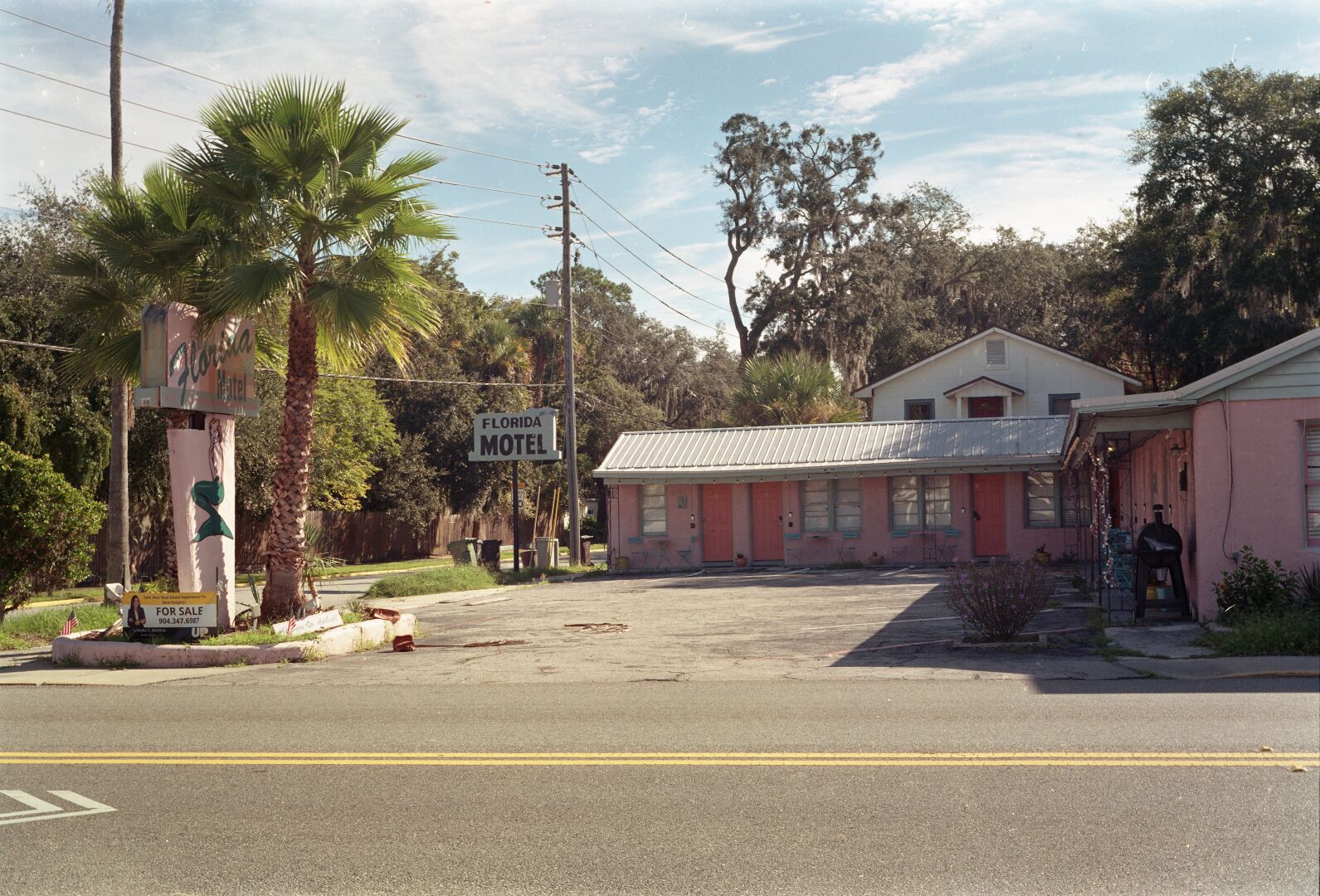 A run down small motel has two signs out front that say “Florida Motel”. The one along the main road also has a mermaid on it. A for sale sign in front of that sign suggests that this motel may not be long for this world.