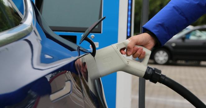 Nahaufnahme eines CCS-Steckers, der in einem Elektroauto steckt.
