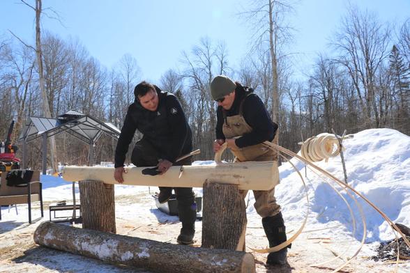 Angello Johnson and his father, Eric Sunday, prepare a black ash log for weaving together. The Mohawk tradition of basketweaving depends on black ash trees, which are threatened with extinction by the invasive emerald ash borer.