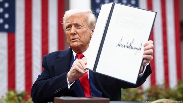 Donald Trump holds up a signed executive order implementing new reciprocal tariffs