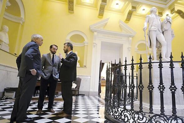 Richard Cullen, left, Chief Counsel for Gov. Glenn Youngkin and Matt Moran, center, Deputy Chief of Staff for the Governor, confer with Sen. Chap Petersen, D-Fairfax, right, in the Rotunda inside the State Capitol in Richmond, Va., Wednesday, March 9, 2022. (Bob Brown/Richmond Times-Dispatch via AP)