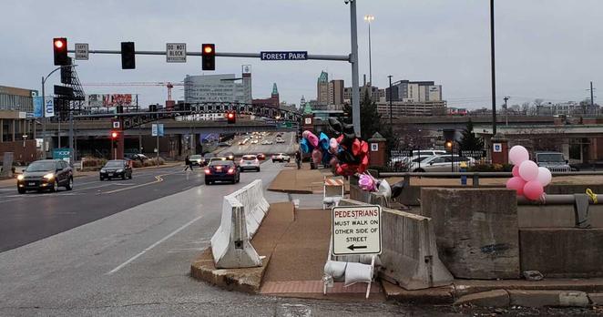 Balloons are placed at the intersection of South Grand Boulevard and Forest Park Avenue, where four people were killed and four others injured after a vehicle ran a red light, crashed into the SUV they were in and sent it hurtling over an overpass.