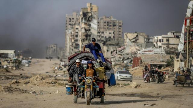 Drei Männer auf einem Motorrad mit überladenem Anhänger in Gaza