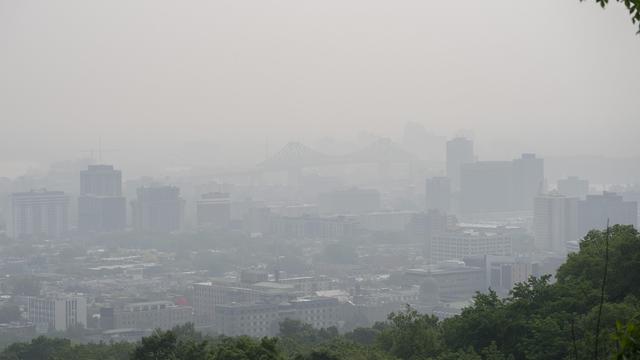 Du haut du mont Royal, on peine à distinguer le centre-ville de Montréal, enveloppé par le smog.