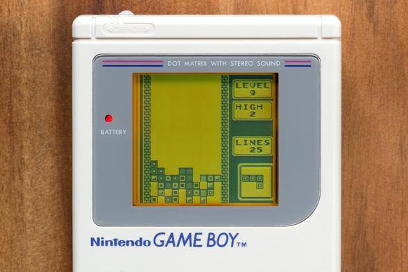 Monochrome screen shows falling Tetris blocks and score display