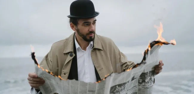 Photo by Anastasia Shuraeva: https://www.pexels.com/photo/a-bearded-man-reading-a-burning-newspaper-7539726