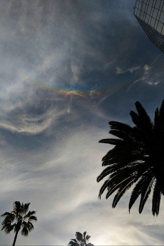 Wispy clouds and what looks like an upside-down rainbow near the top of the sky.