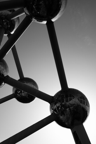 Atomium Brussels, huge metallic monument that represents an Atom : spheres linked between them.
Clear sky behind.

Black and white photography.