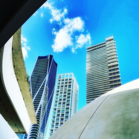 High rise buildings standing up in the blue sky