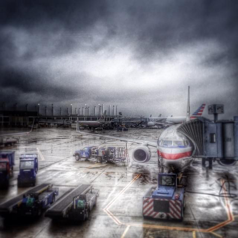 Airport covered with dark grey winter cloud. A airplane is at the gate