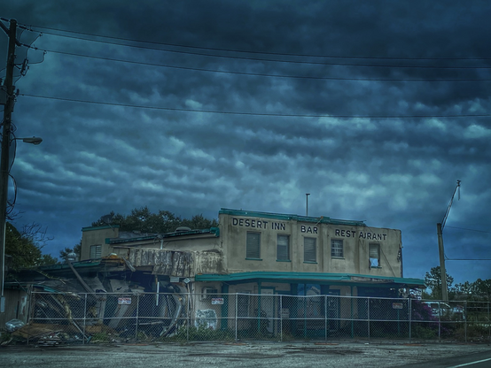 Abandoned hotel collapsed left side and fenced around 