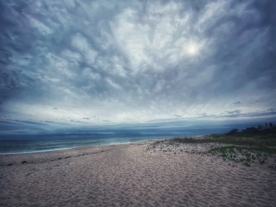 Winter beach. Thick clouds and grey bluish ocean and beach