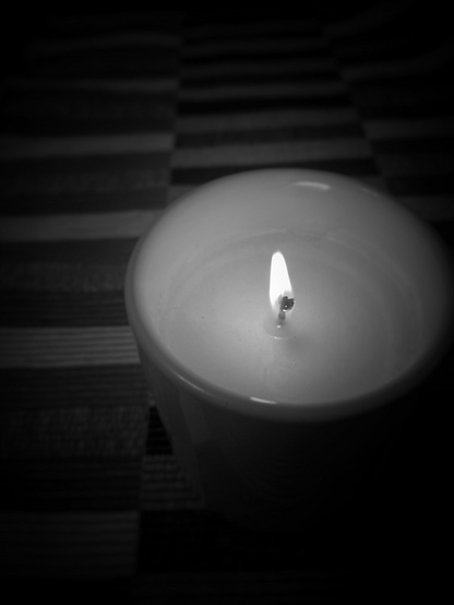 A candle is lit in the dark background 