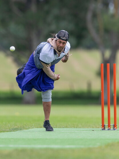 A kilikiti bowler in his follow through as the ball heads down the wicket.